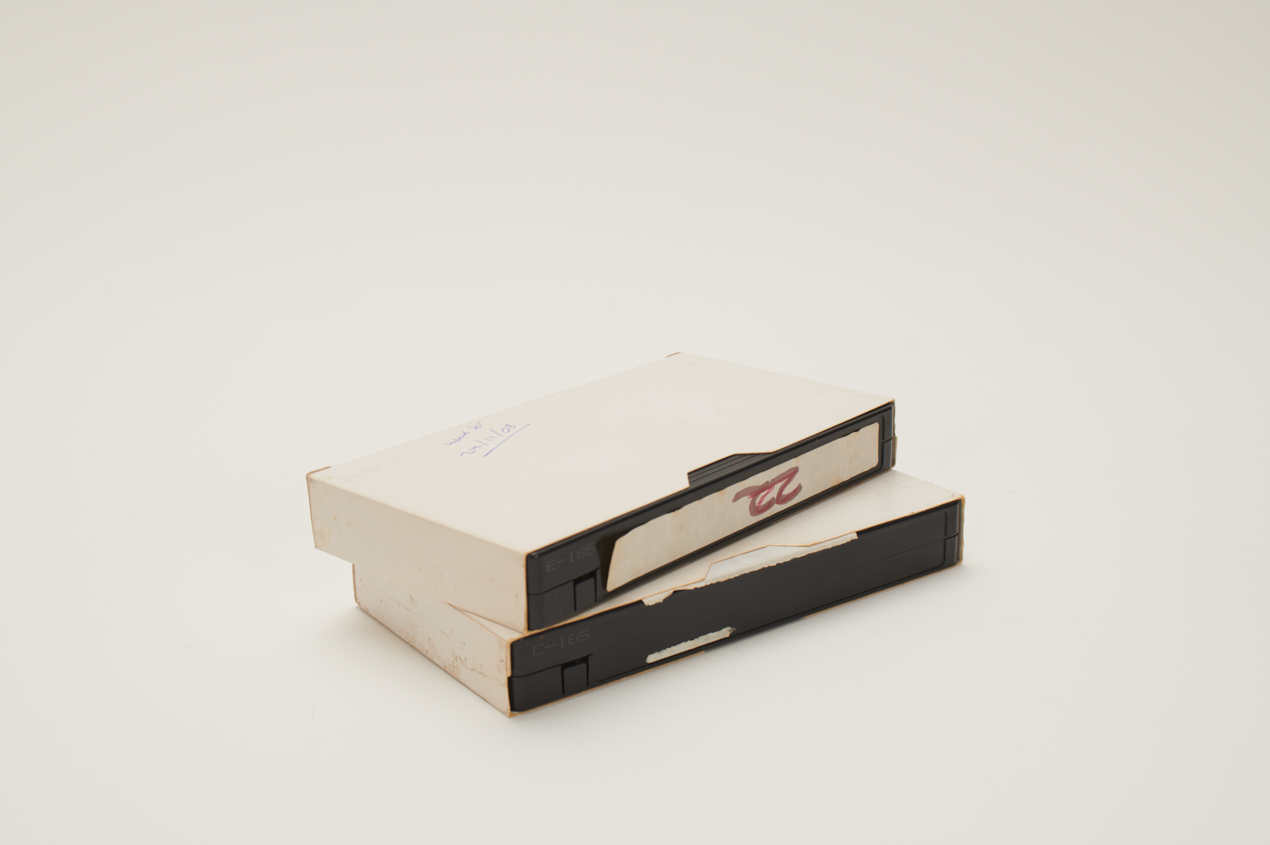 Two salvaged videocassettes in white archive cases
