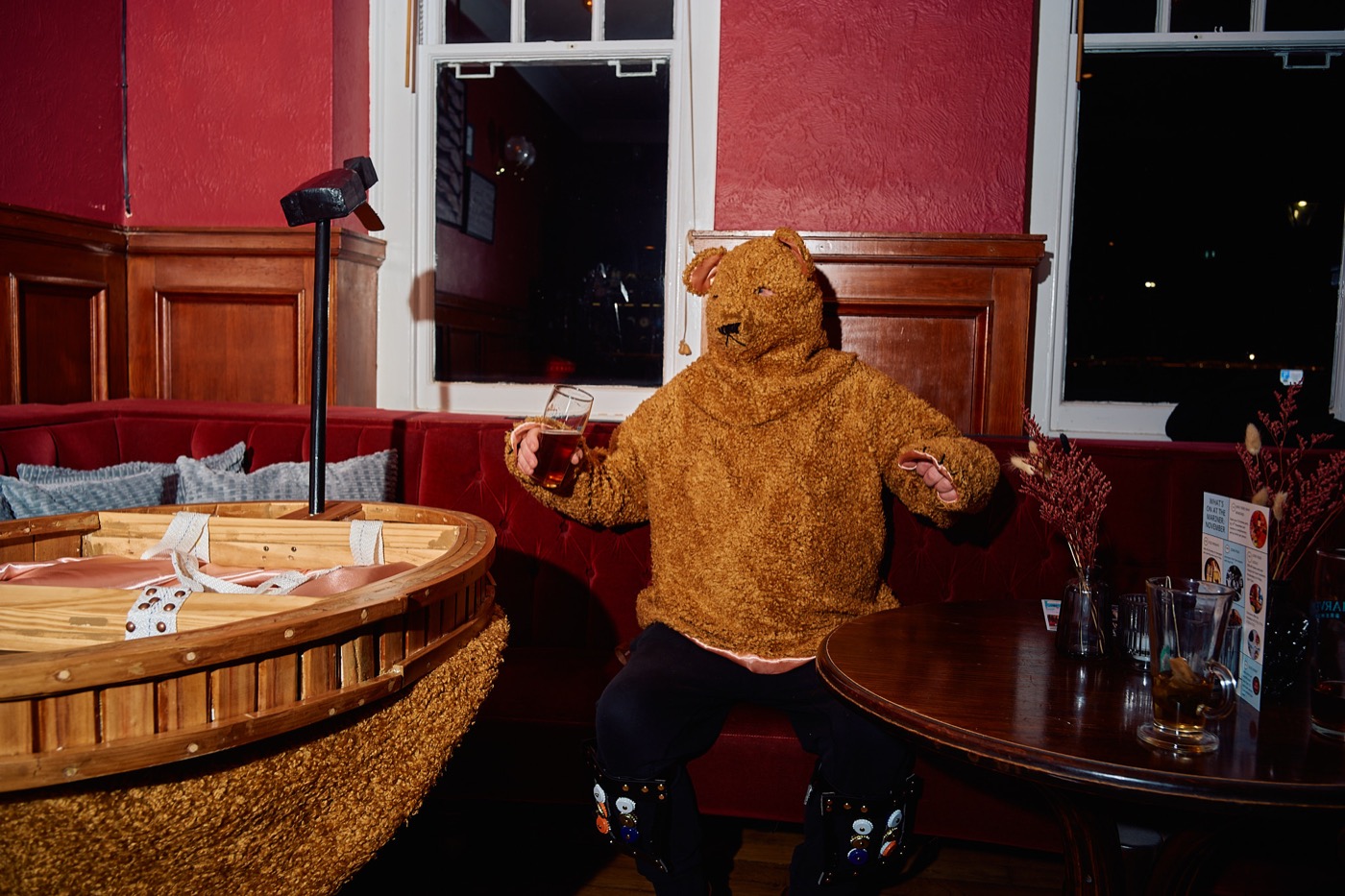The Bear seated beside the portable ring in a pub