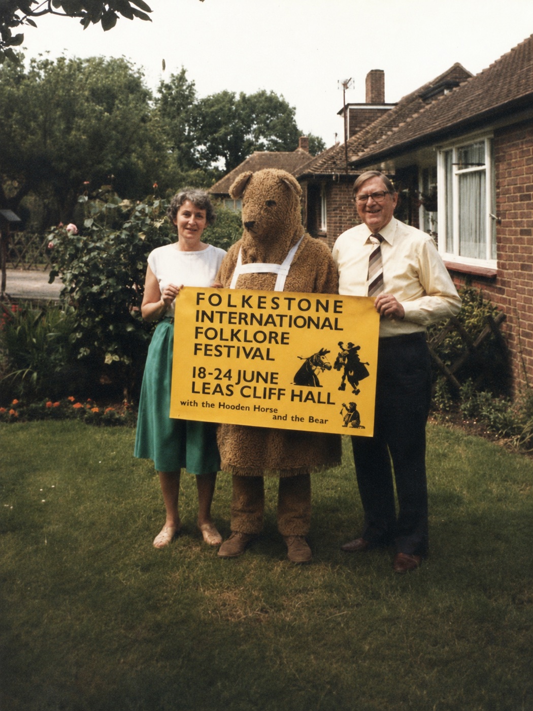 The Bear holding a Folkestone International Folklore Festival sign