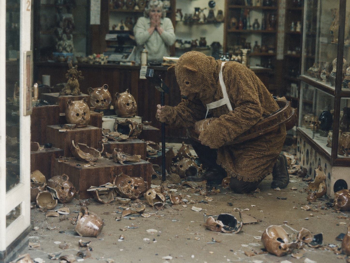 The Bear kneeling among broken pottery bears inside Prima Pottery