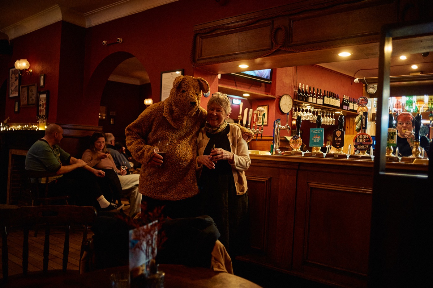 The Bear beside a pub patron at the bar inside the Mariner