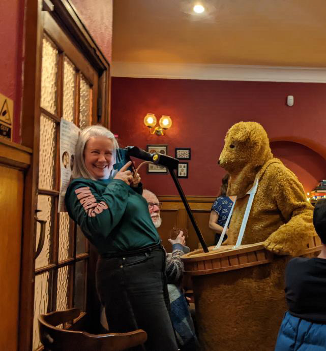 A Trad Folk Night participant holding the Horse microphone beside the Bear