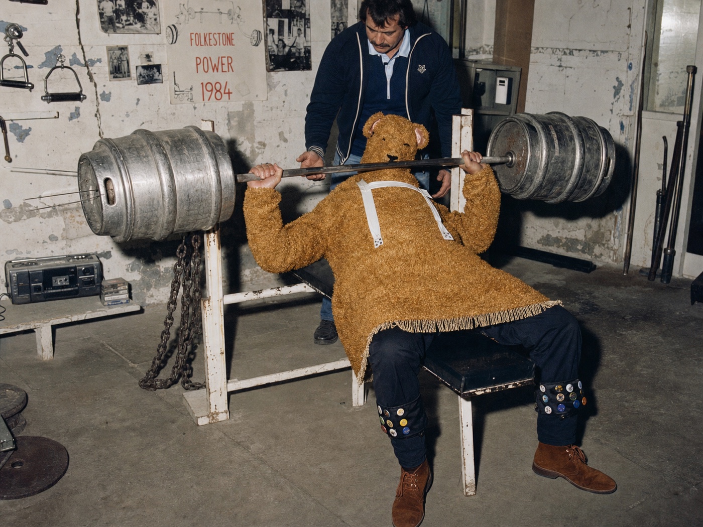 The Bear bench pressing a bar weighted with beer kegs