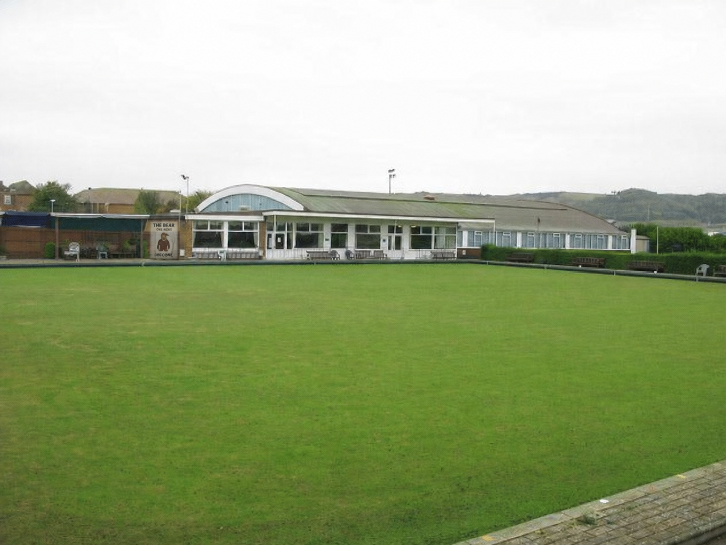 Folkestone bowls green with a small Bear event poster on the clubhouse