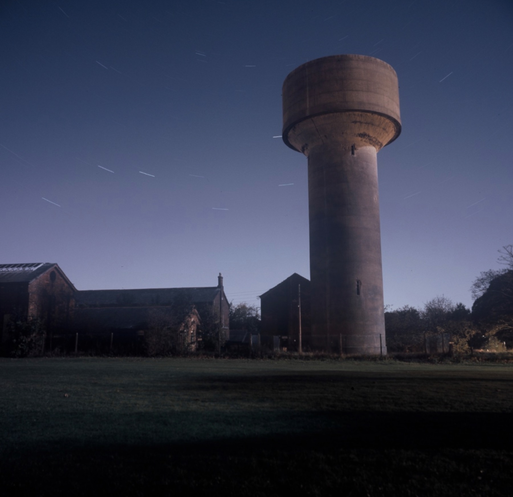 Concrete water tower beside former barracks buildings