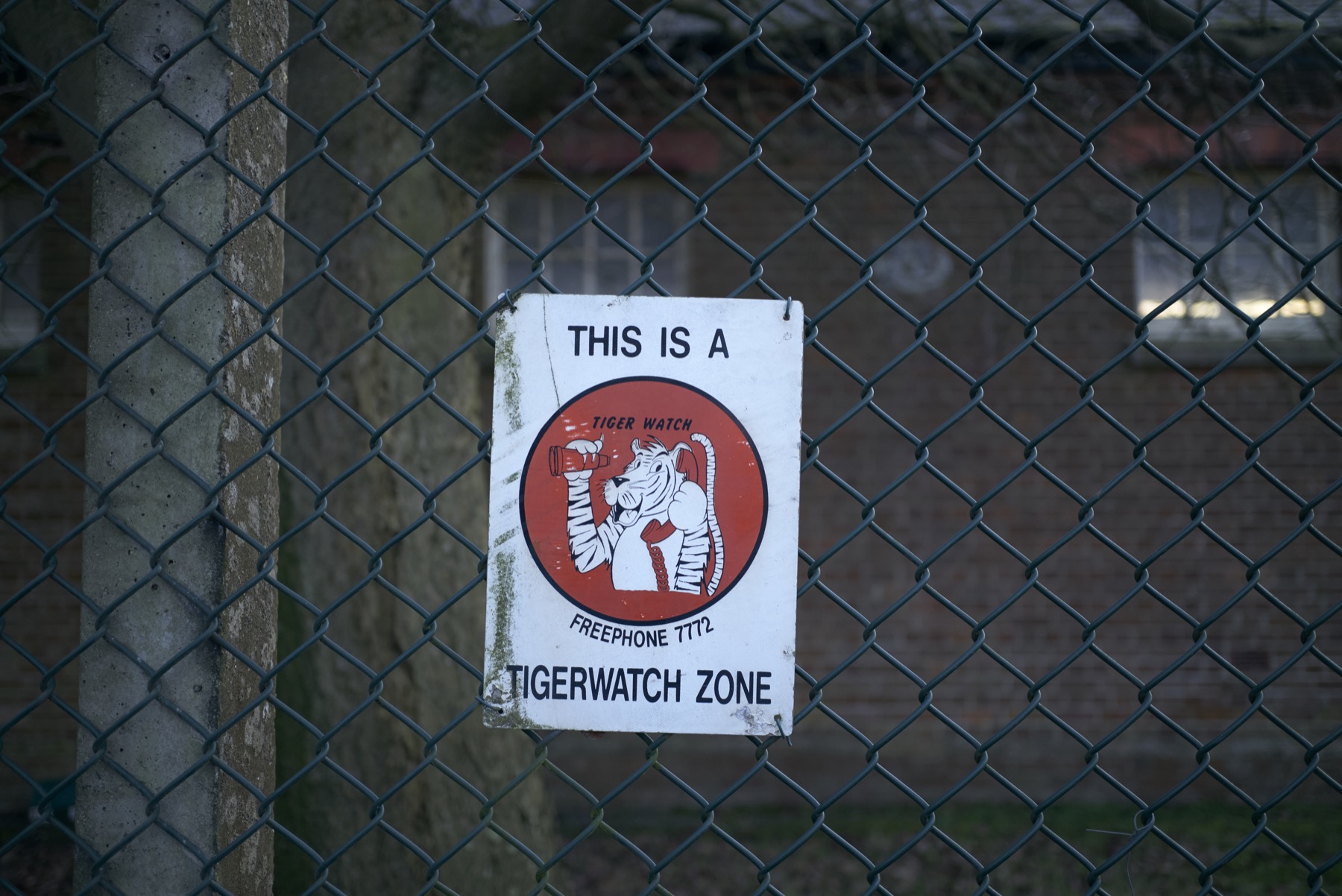 Tiger Watch sign fixed to a chain-link security fence